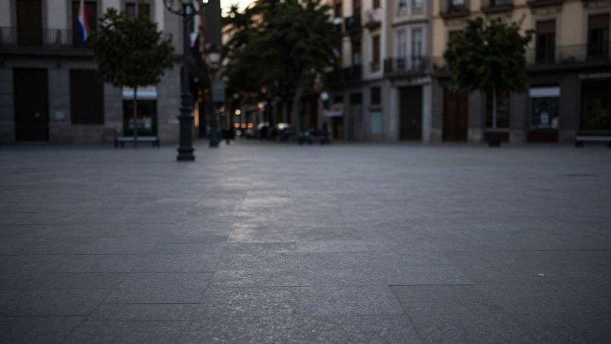 Imagen ilustrativa: plaza urbana vacía al amanecer con una figura lejana de espaldas y mucho espacio negativo