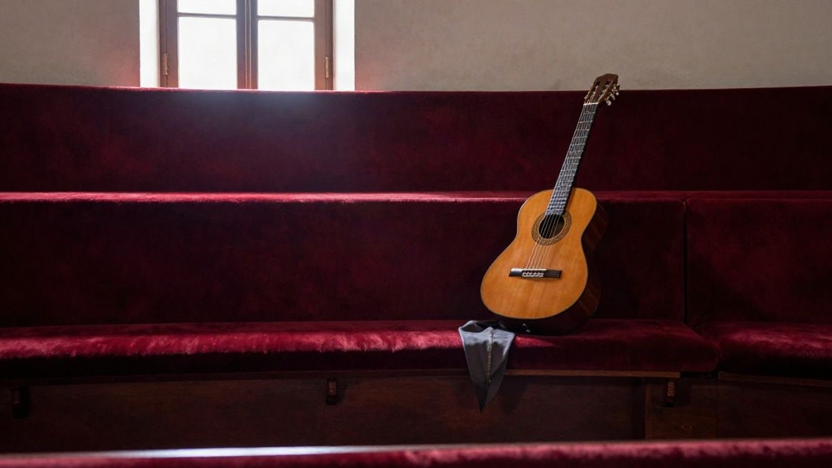 Imagen ilustrativa: un escenario teatral vacío con un mantón de manila y una guitarra, iluminado por luz lateral