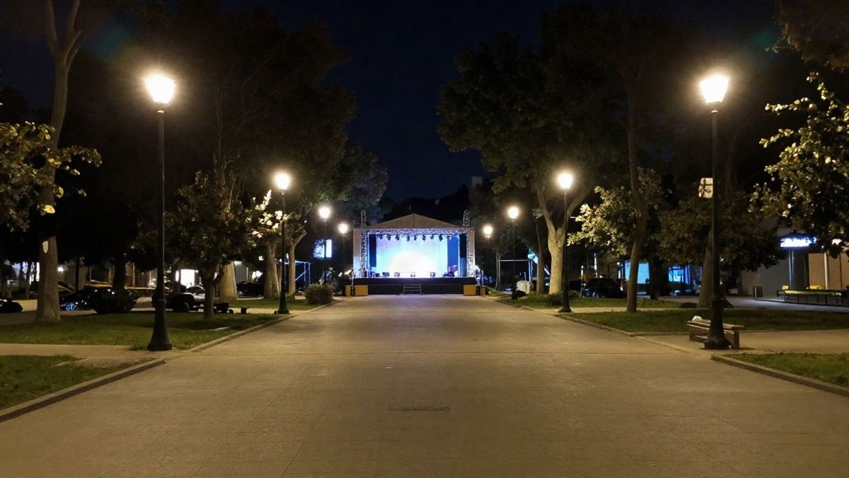 Imagen ilustrativa: un parque urbano iluminado por farolas y focos durante la noche