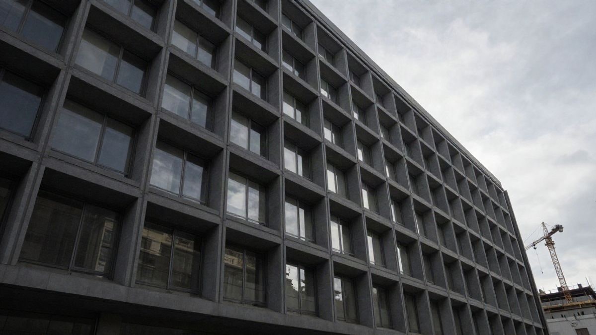 Imagen ilustrativa: ángulo bajo de un edificio de oficinas moderno con cielo de fondo y una grúa de construcción al fondo