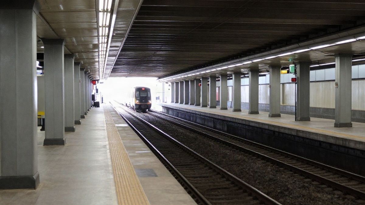 Imagen ilustrativa: andén de metro moderno con líneas convergentes y un tren alejándose al fondo