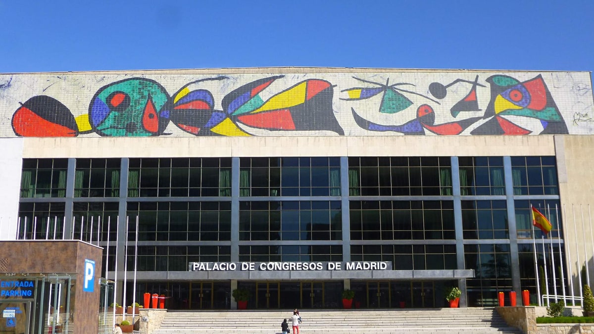 Fachada del Palacio de Congresos de Madrid con mural de colores, escalinata y cielo despejado