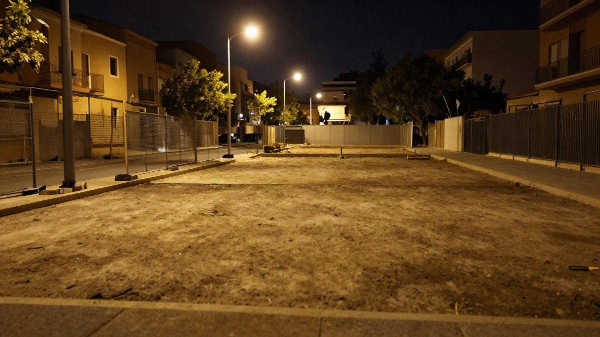 Imagen ilustrativa: solar urbano vacío iluminado por farolas en un barrio residencial