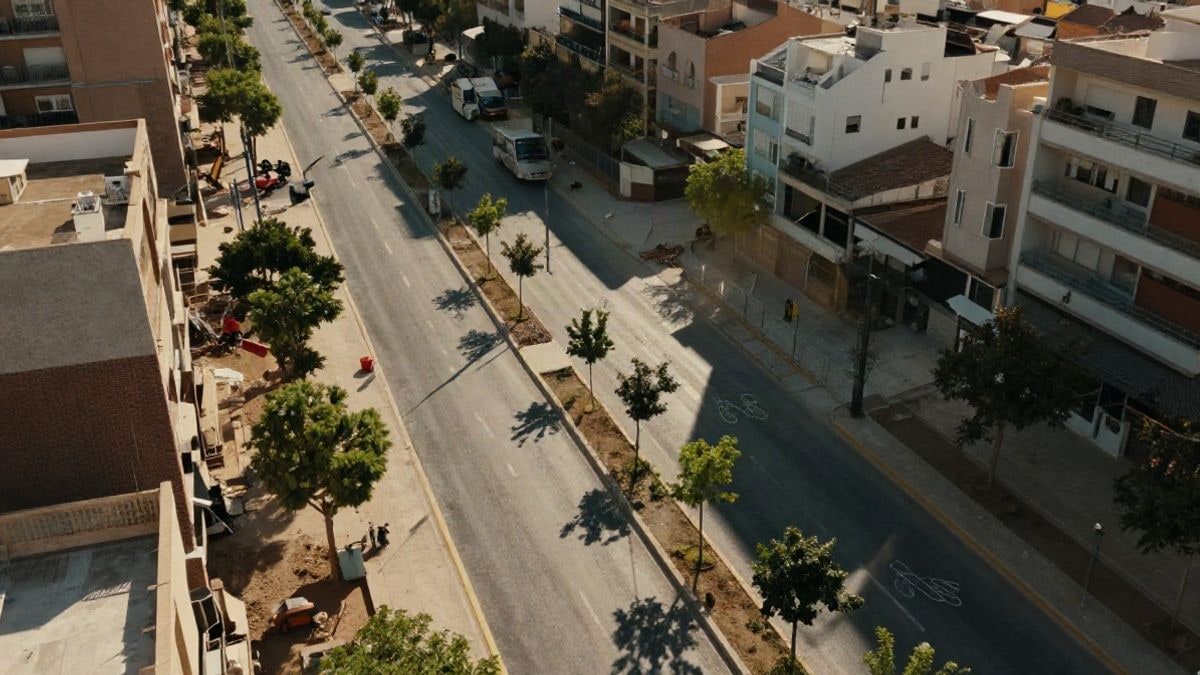 Imagen ilustrativa: vista aérea de un bulevar urbano en construcción con hileras de árboles y carriles separados.