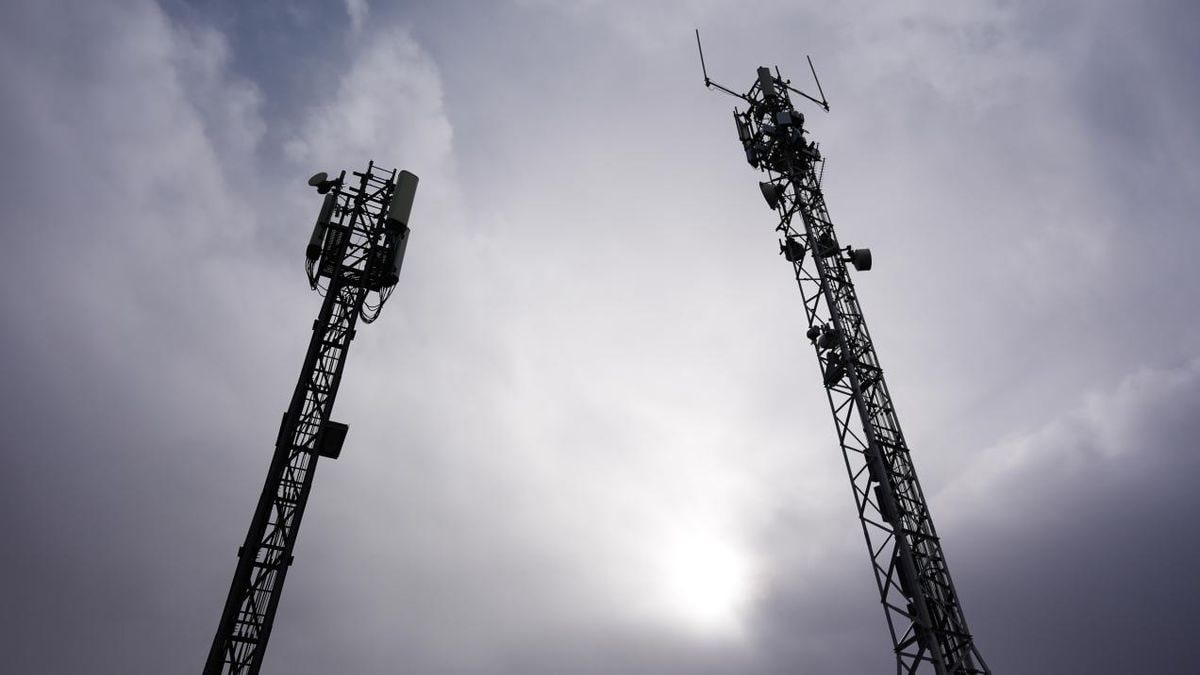 Imagen ilustrativa: carretera rural con torres de telecomunicaciones al fondo al atardecer