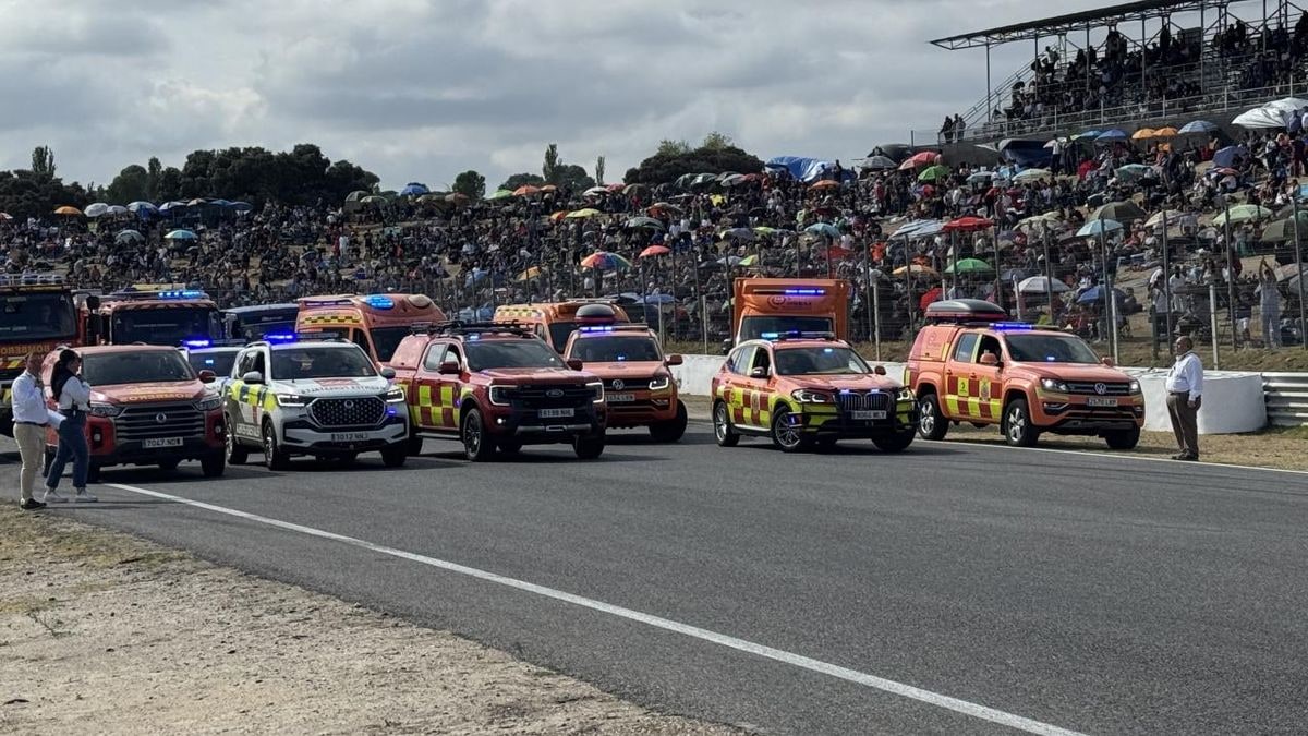 Imagen ilustrativa: vista en gran angular del pit lane de un circuito de carreras con gradas vacías y un vehículo oficial estacionado
