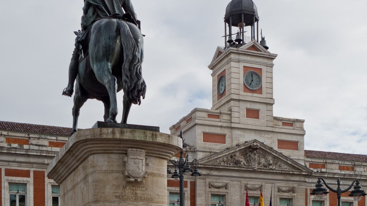Estatua ecuestre de Carlos III frente a la torre del reloj de la Real Casa de Correos