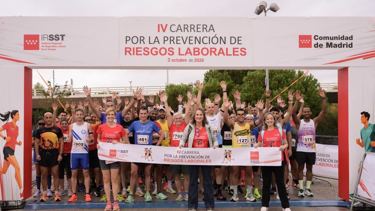 Imagen ilustrativa: línea de salida de una carrera popular en un paseo junto al río con cielo nublado