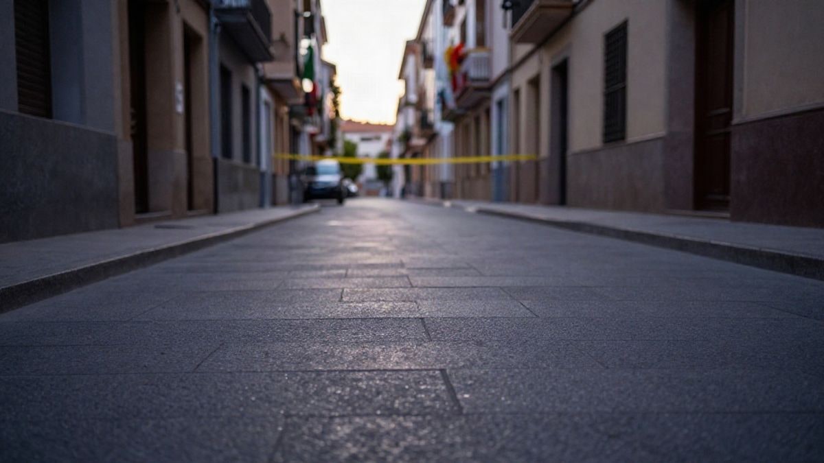 Imagen ilustrativa: calle residencial española al atardecer con cinta policial en una puerta al fondo