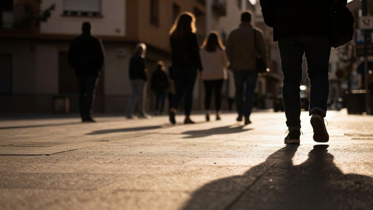 Imagen ilustrativa: siluetas de personas en una calle urbana al atardecer con sombras alargadas sobre el pavimento
