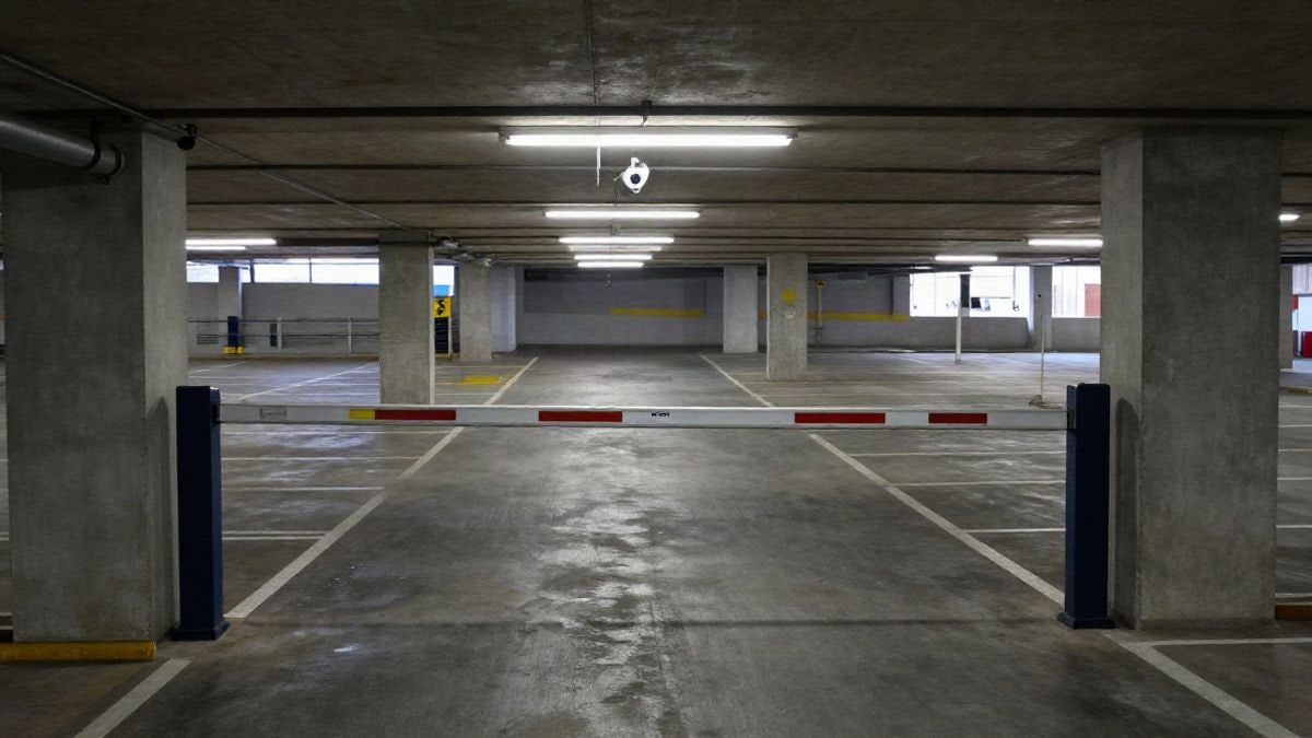 Imagen ilustrativa: vista cenital de un aparcamiento subterráneo vacío con cámaras de seguridad en el techo