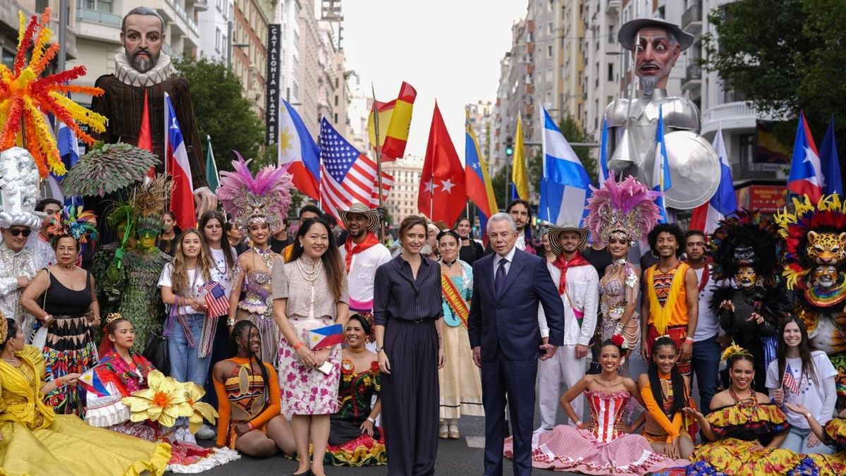 Imagen ilustrativa: una avenida urbana española engalanada con carrozas de colores durante un desfile