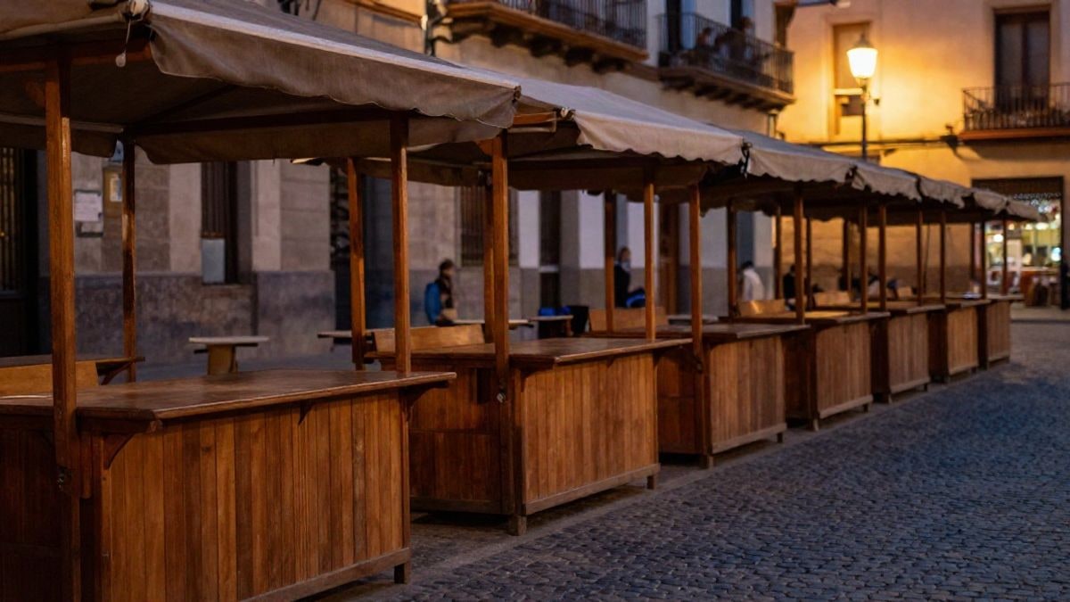 Imagen ilustrativa: puestos de mercadillo vacíos en una plaza española al atardecer