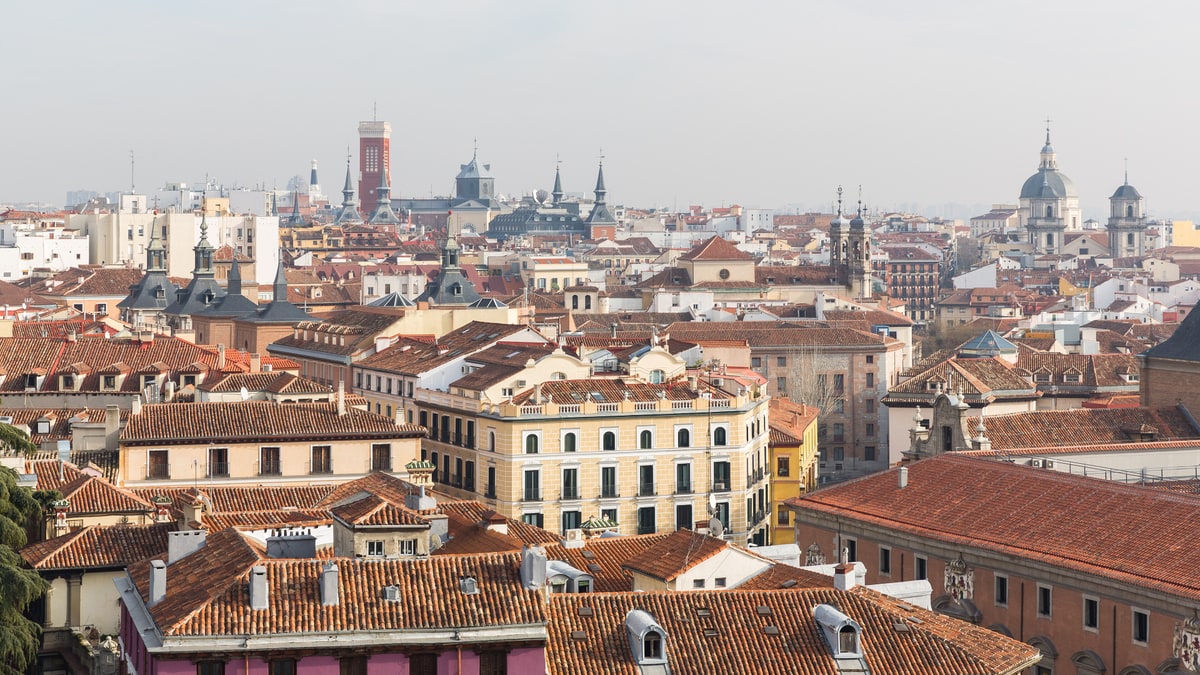 Tejados rojos del casco histórico de Madrid con cúpulas y torres al fondo bajo cielo gris