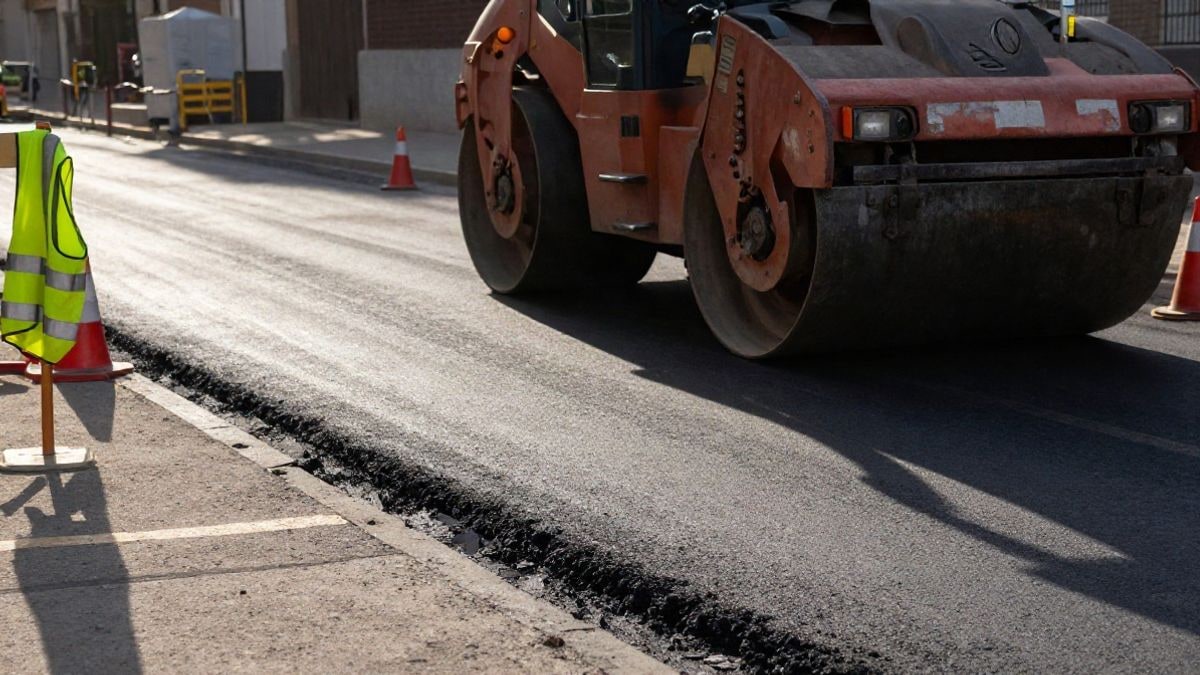 Imagen ilustrativa: tramo de carretera en obras con maquinaria y conos de señalización al atardecer