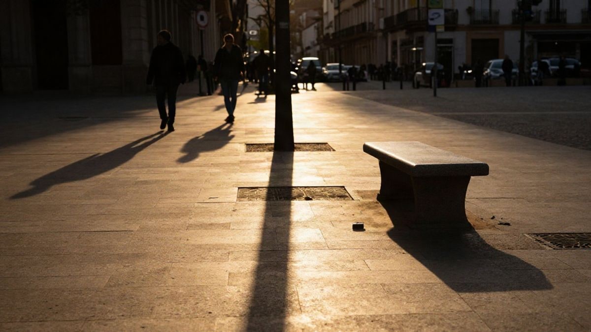 Imagen ilustrativa: contraluz al atardecer en una plaza pública con sombras largas y objetos en el suelo