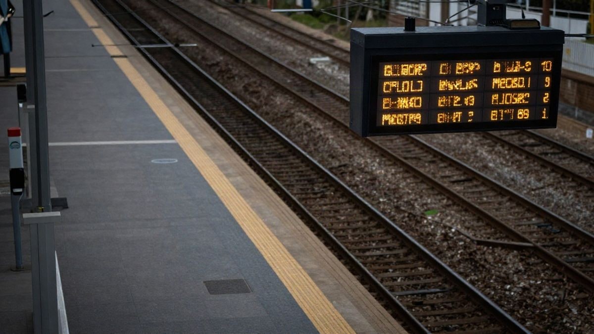 Imagen ilustrativa: vista cenital de un andén de tren suburbano con vías vacías y panel de salidas