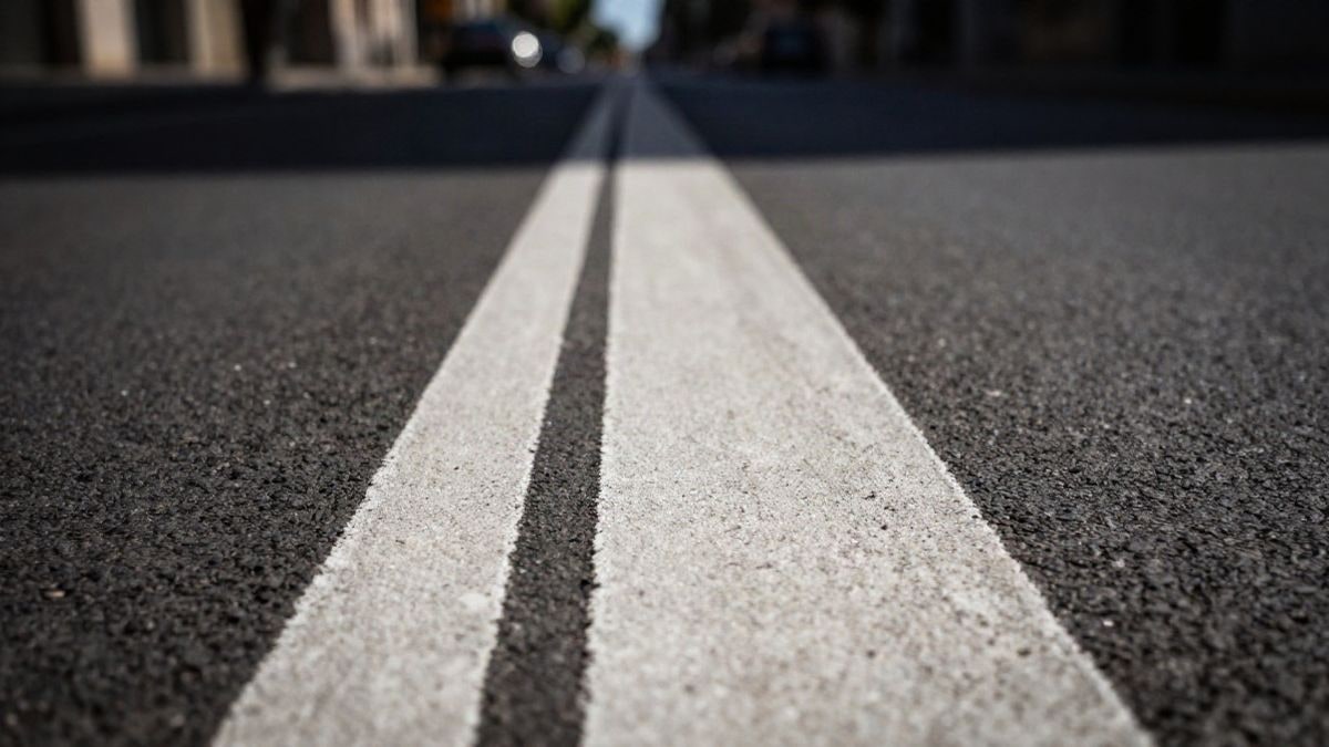 Imagen ilustrativa: primer plano de una doble línea blanca pintada sobre el asfalto de una calle