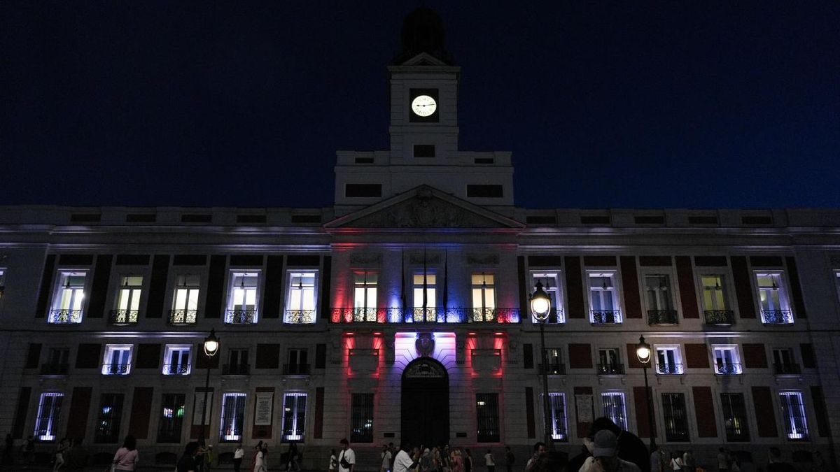 Imagen ilustrativa: fachada de un edificio gubernamental iluminado con luces blancas y negras al atardecer.