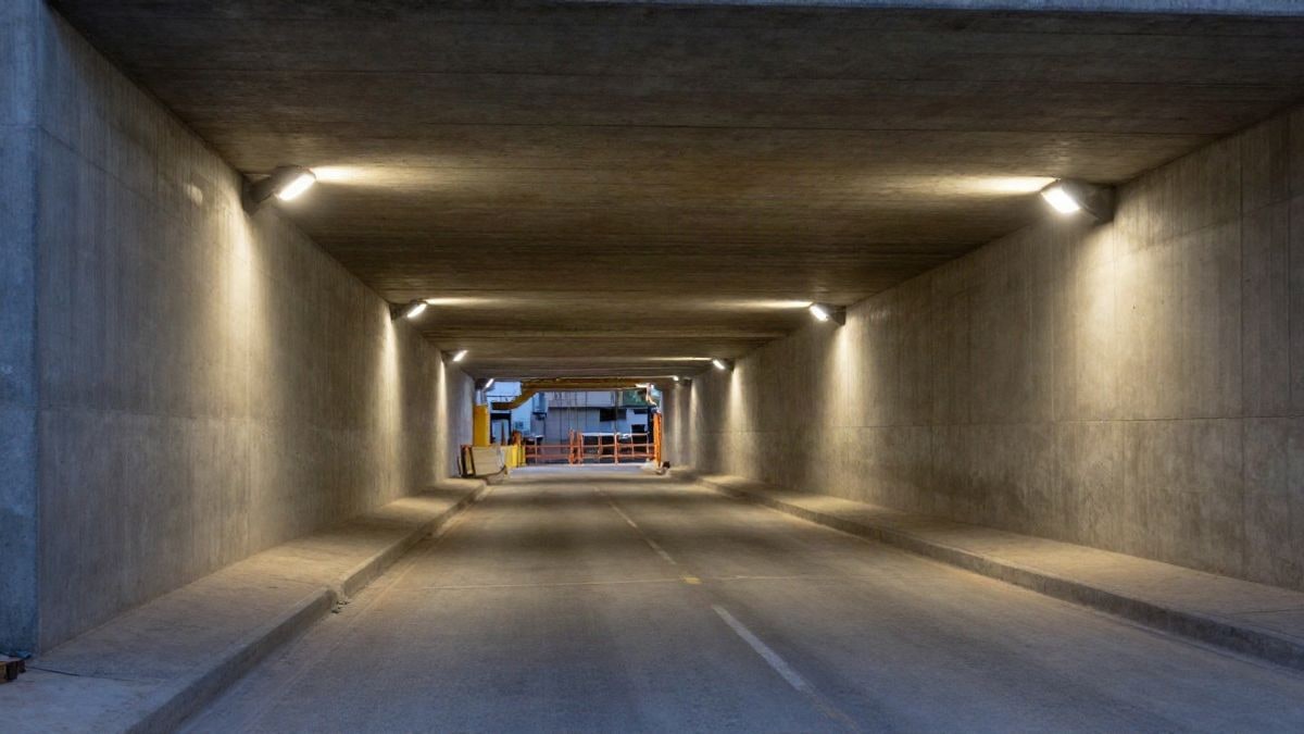 Imagen ilustrativa: un túnel urbano en obras con líneas que convergen y luces de obra al fondo