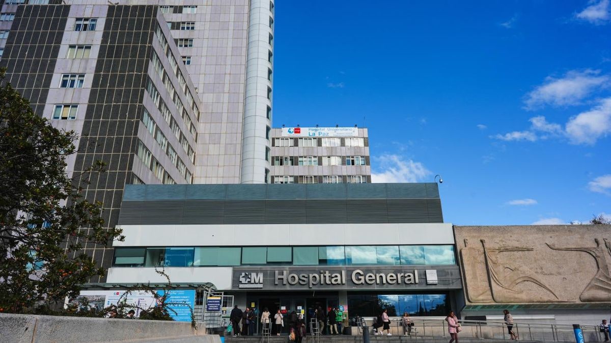 Imagen ilustrativa: detalle de una hoja verde en primer plano con un edificio hospitalario moderno al fondo