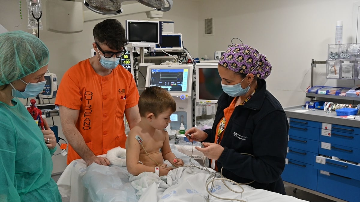 Imagen ilustrativa: pasillo de hospital con luz natural y una camilla infantil al fondo, sin personas reconocibles.