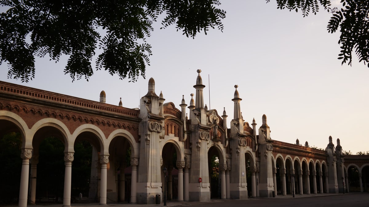 Fachada monumental de entrada al Cementerio de La Almudena al atardecer, sin visitantes