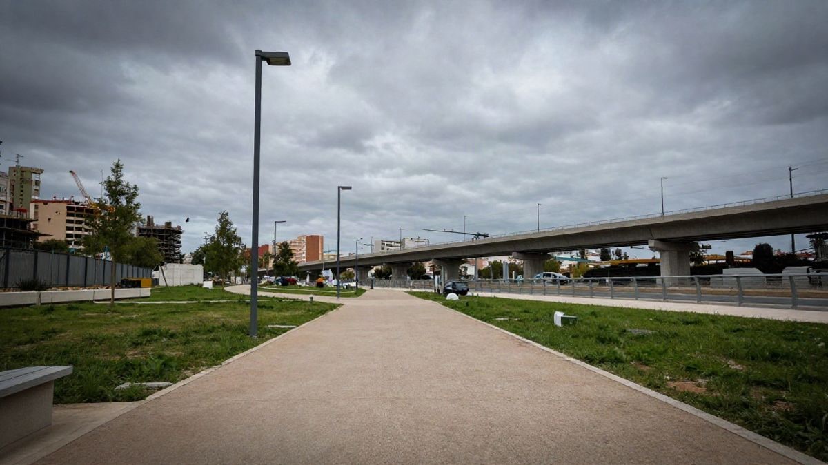 Imagen ilustrativa: vista a ras de suelo de un parque urbano en construcción con pasarelas peatonales sobre una autovía, con cielo de fondo