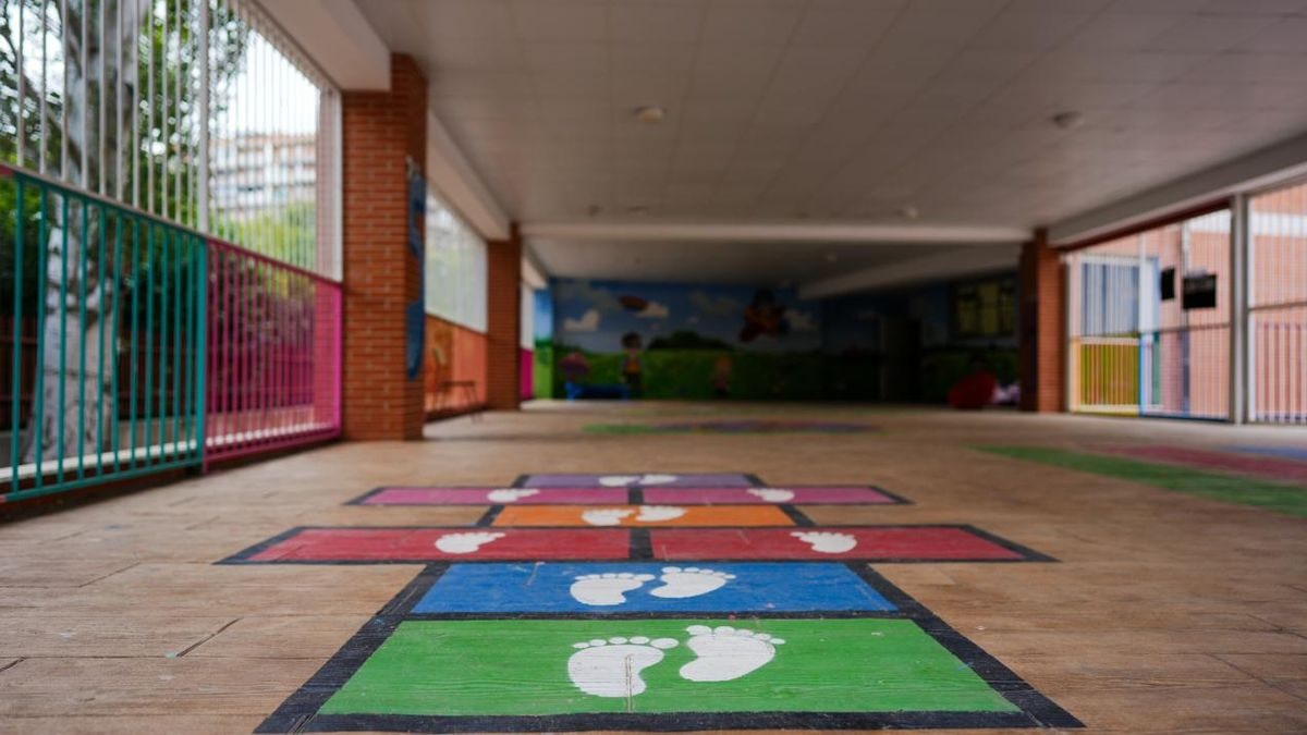 Imagen ilustrativa: patio de un colegio con juegos infantiles y puertas abiertas, iluminado por la luz de la mañana.