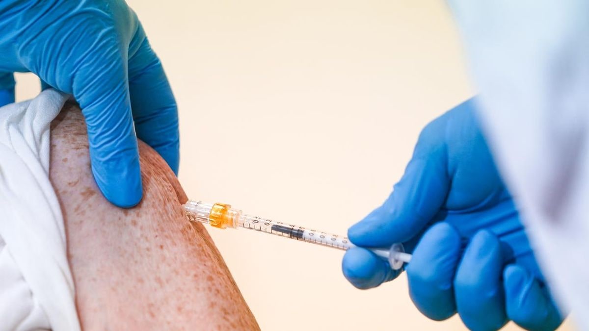Imagen ilustrativa: un vial de vidrio y una jeringuilla sobre una bandeja de acero inoxidable en un entorno sanitario
