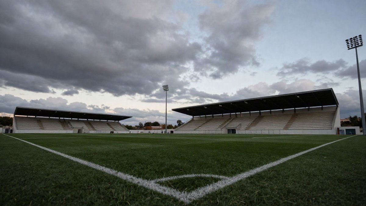 Imagen ilustrativa: campo de fútbol vacío con graderío cubierto al atardecer