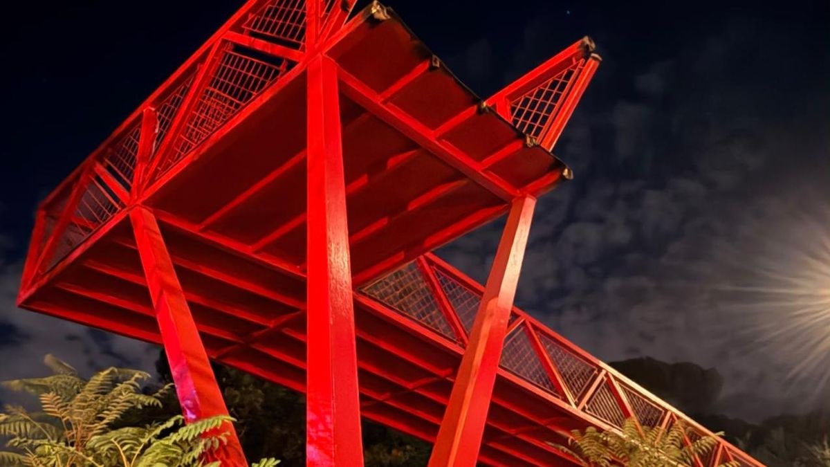 Imagen ilustrativa: una pasarela peatonal moderna cruza una autovía urbana al atardecer, con líneas que convergen hacia el fondo