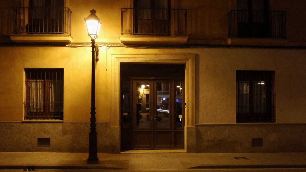 Imagen ilustrativa: portal de un edificio residencial de noche bajo la luz de una farola