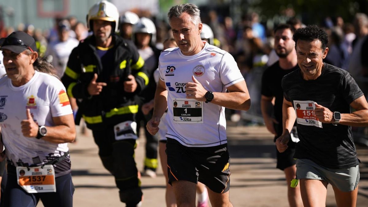 Imagen ilustrativa: camino pavimentado de una carrera popular junto a un parque fluvial, con un casco de bombero en primer plano