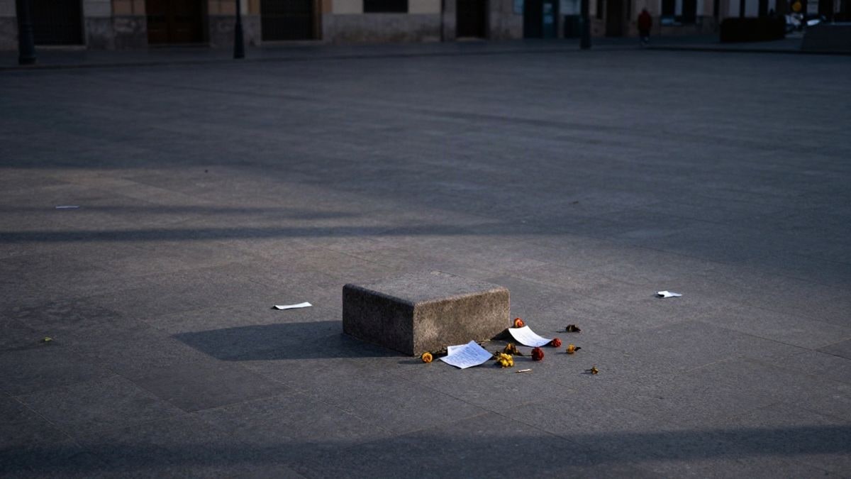 Imagen ilustrativa: escalinata de piedra vacía en una plaza urbana al atardecer, con papeles dispersos en el suelo.