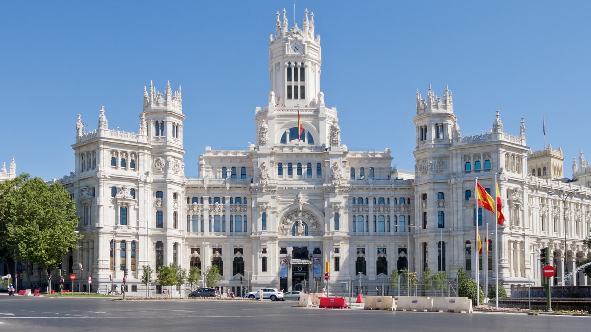Fachada del Palacio de Comunicaciones con banderas de España y de Madrid al frente