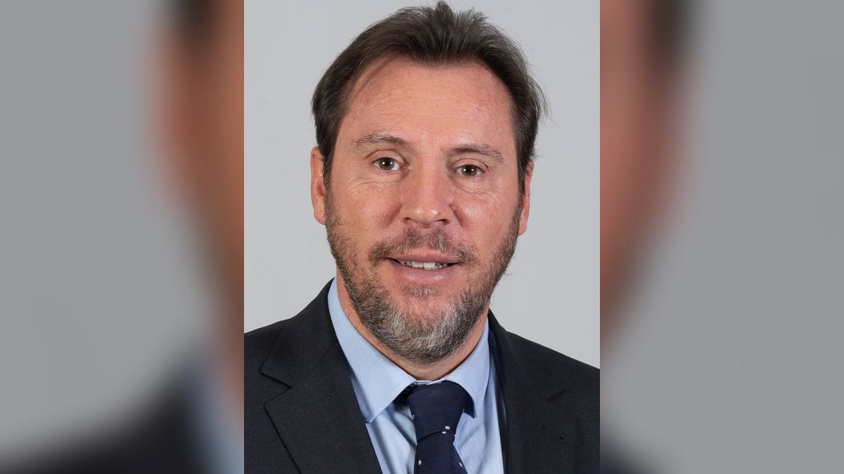 Óscar Puente, ministro de Transportes, con traje oscuro y corbata azul, retrato frontal