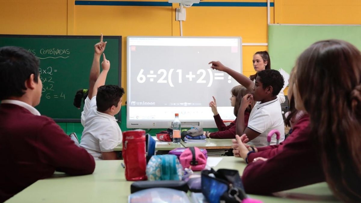 Imagen ilustrativa: aula escolar vacía con pupitres ordenados y luz natural entrando por los ventanales