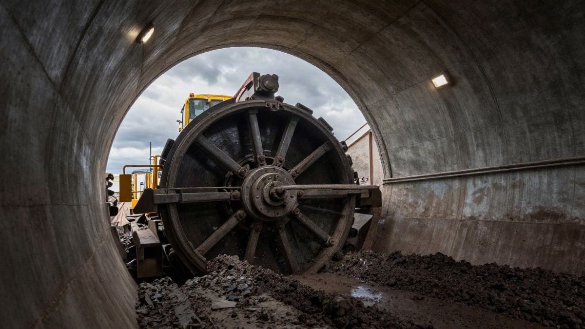 Imagen ilustrativa: una tuneladora gigante en un túnel subterráneo con luces industriales y cielo visible al fondo.