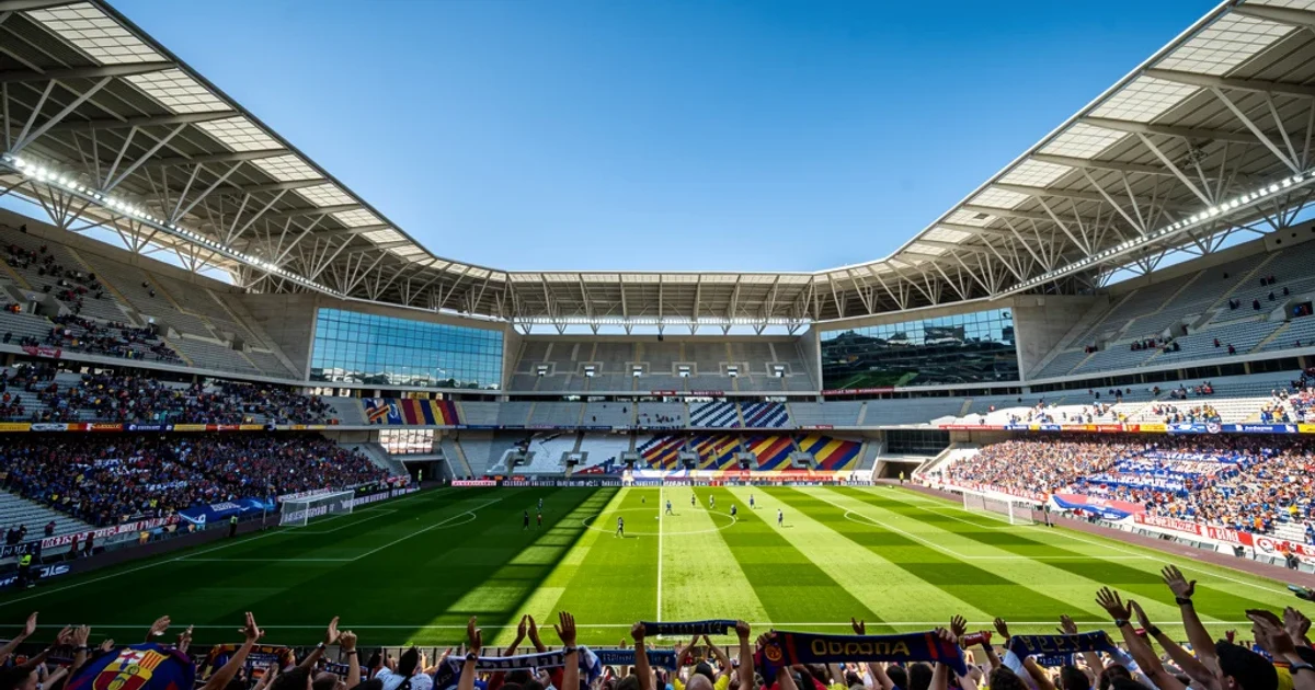 Estadio moderno lleno de aficionados apoyando al equipo durante un partido.